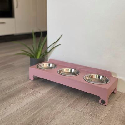 Stainless steel triple-bowl raised feeder in blush pink.