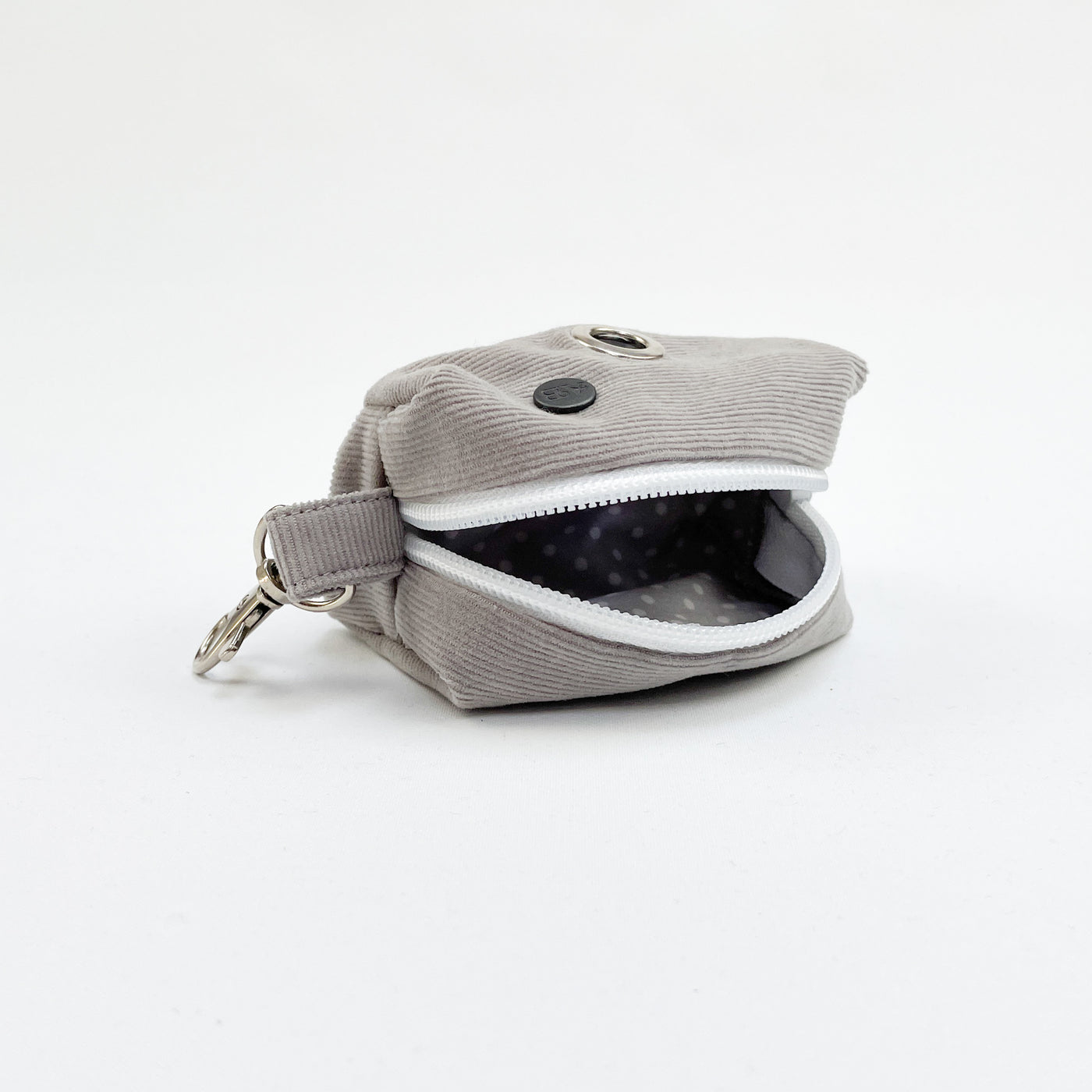 Grey corduroy poop bag holder open showing grey polka dot lining