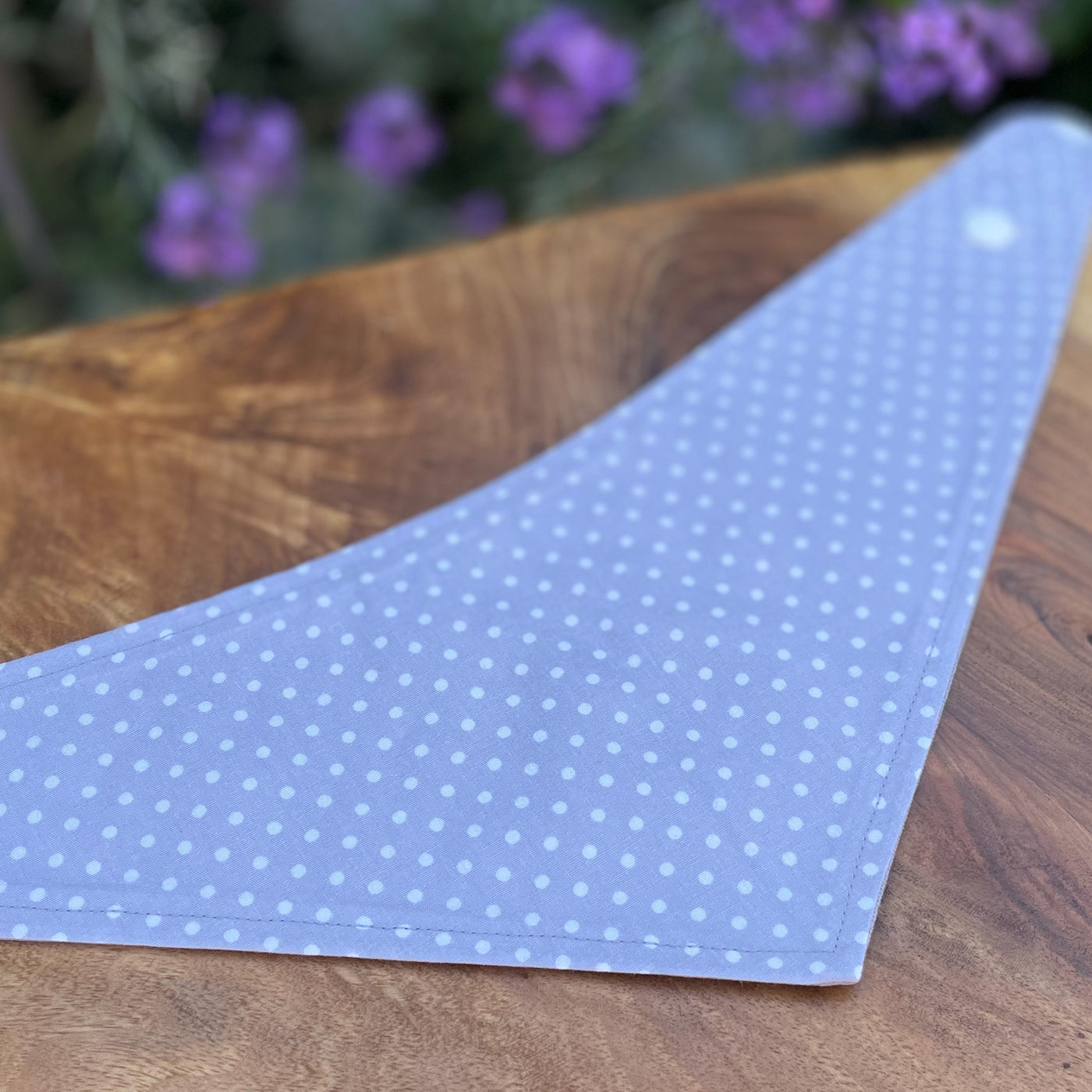Dog bandana with a grey and white polka dot pattern reverse.