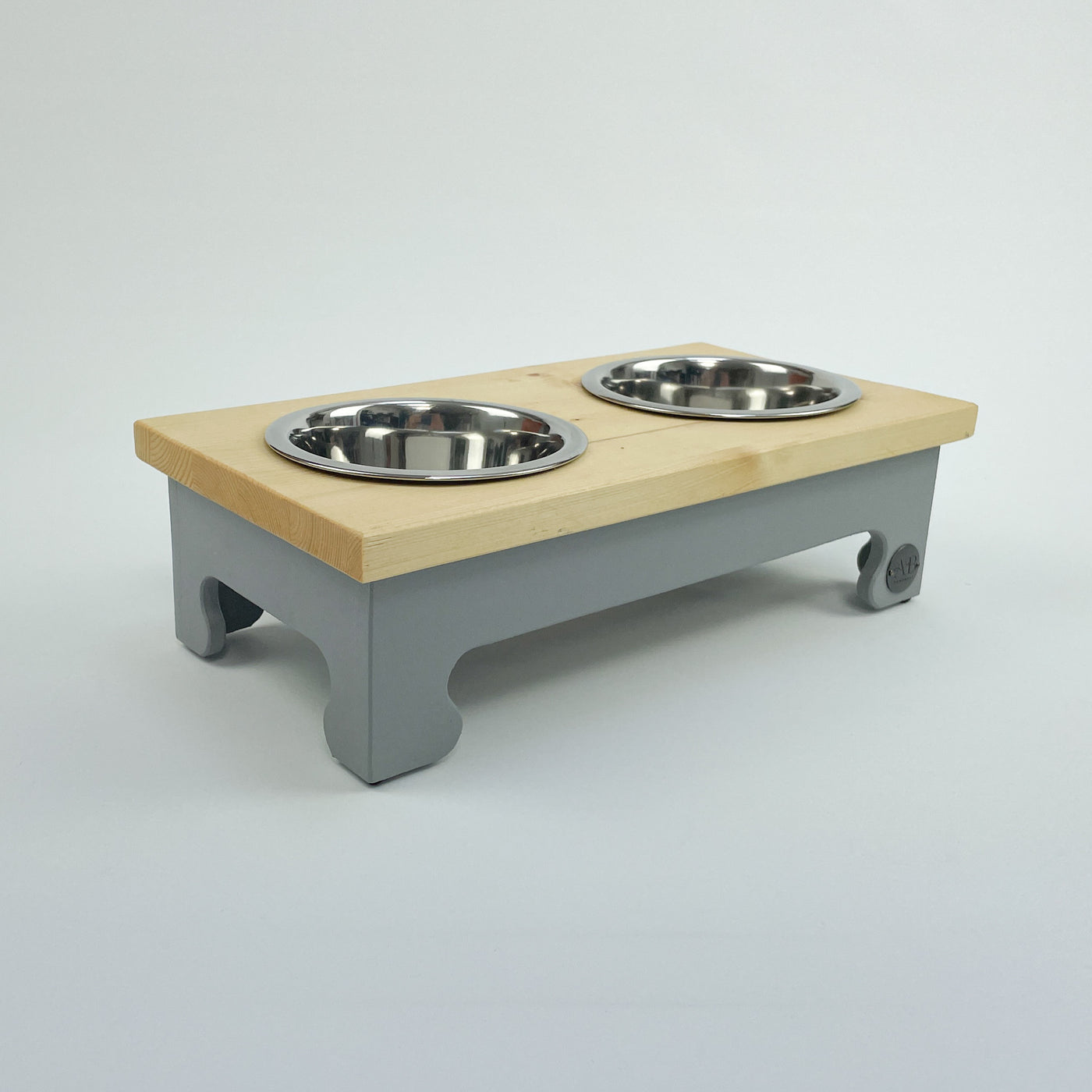Small raised pet feeder in grey with a natural pine top.dog