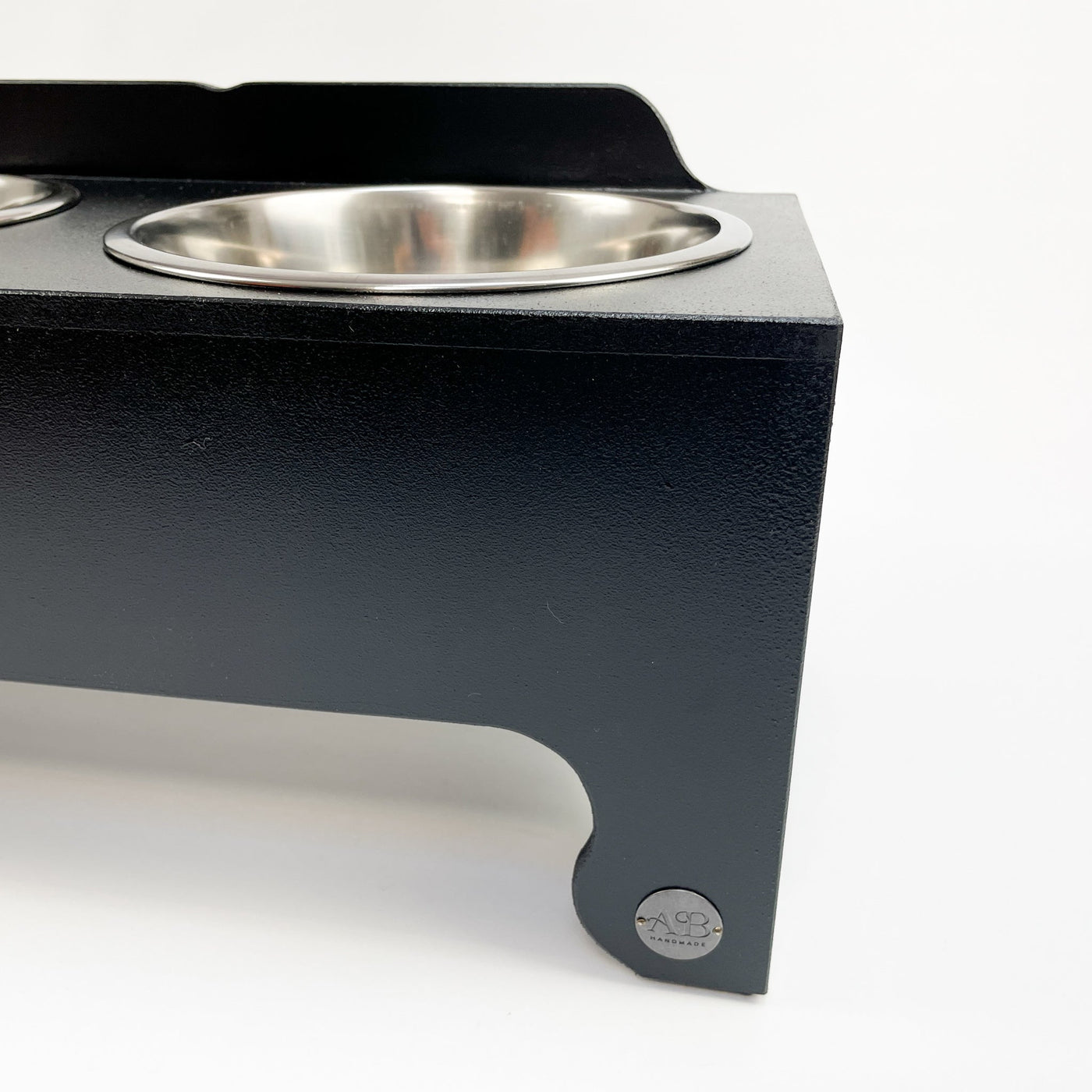 Albie's seal of quality on a black, raised dog-bowl stand