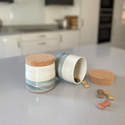 Ceramic treat jars for storing dog biscuits and other treats.