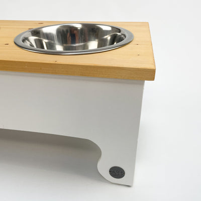 White feeding station for dogs, raised, natural pine top.