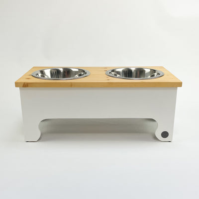 White double-bowl raised feeder for dogs , natural pine top.