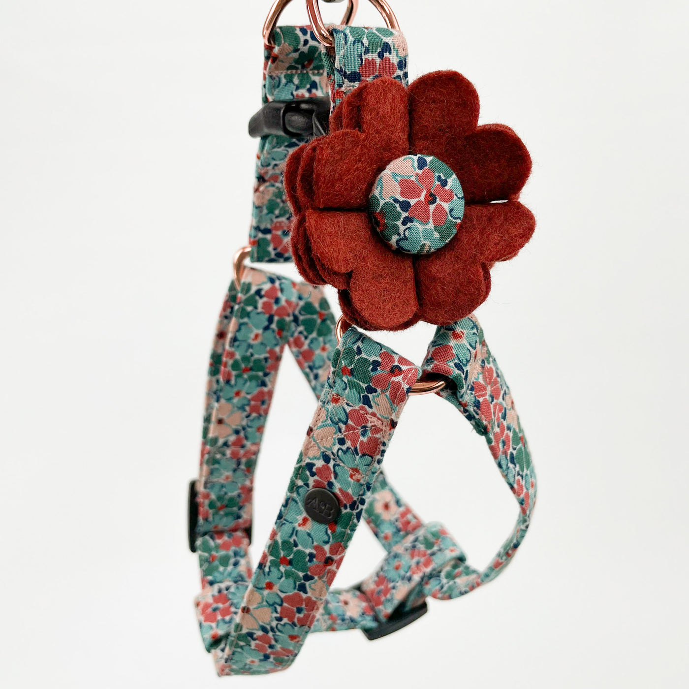 Dog collar flower accessory in burnt umber felt with a Liberty fabric button centre shown on a Liberty floral step-in harness. 