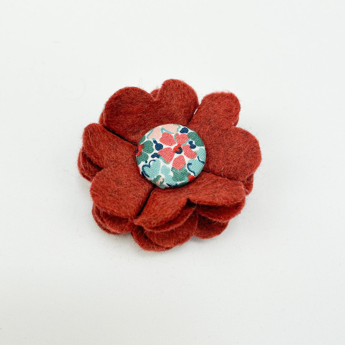 Dog collar flower accessory in burnt umber felt with a Liberty fabric button centre.