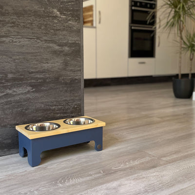 A medium sized pine top raised dog bowl feeding stand in navy.