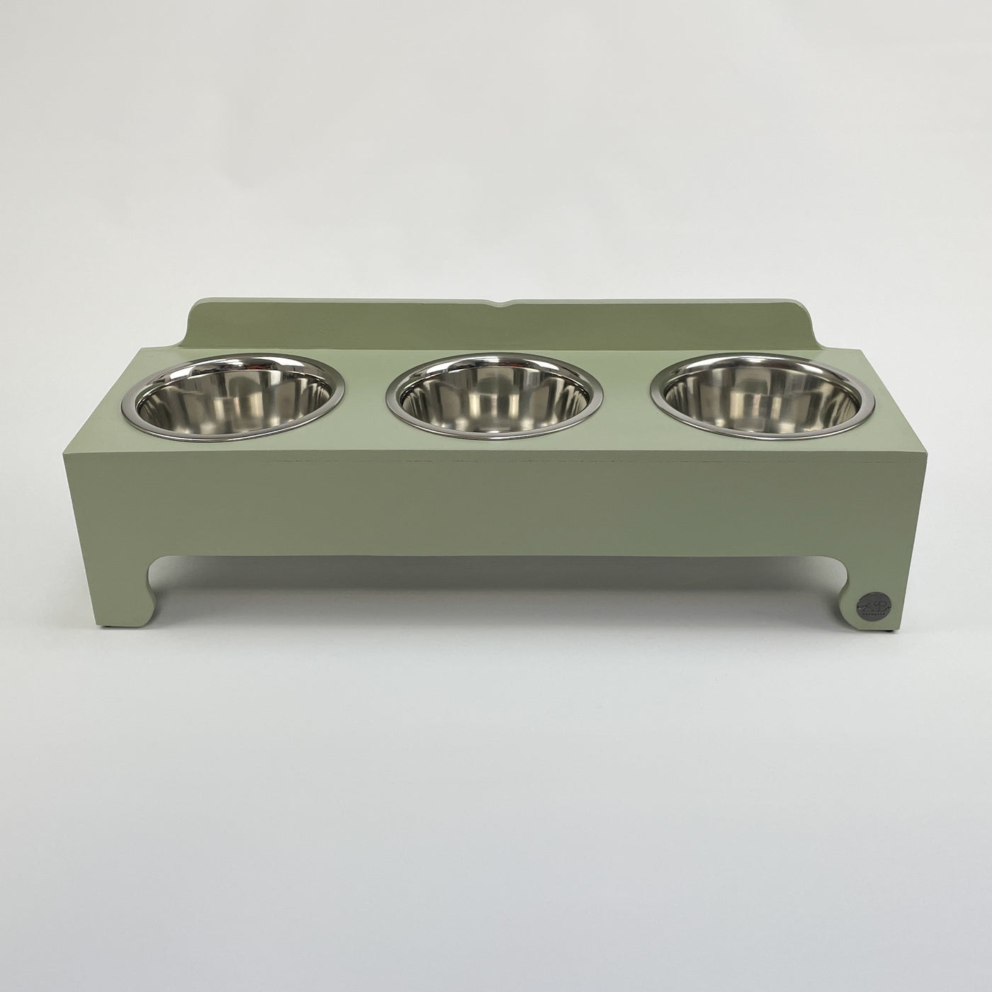 Three-bowl raised dog feeding stand in soft green.