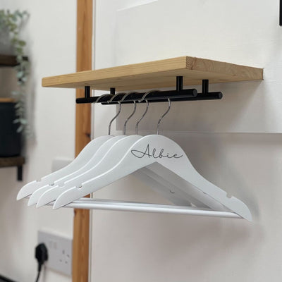 White wooden hangers for dog accessories personalised with the name "Albie".