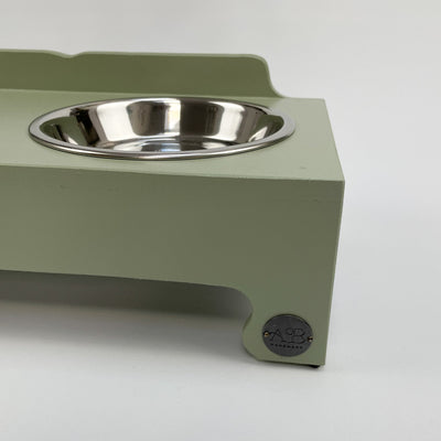 Soft green raised pet feeder for cats and pupies.