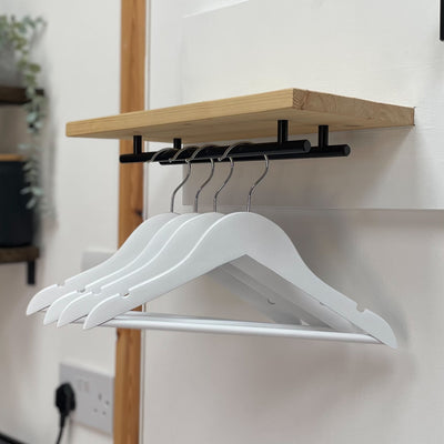 Set of four white, wooden hangers.