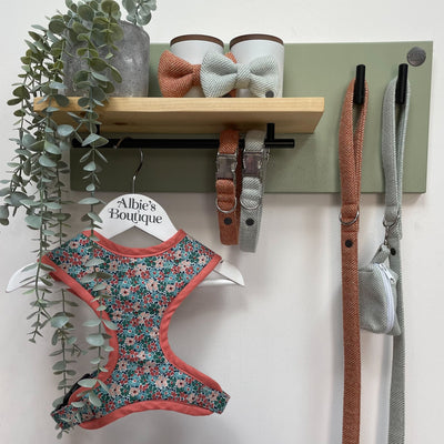  Herringbone fabric dog walking accessories stored and organised on a soft green lead station.